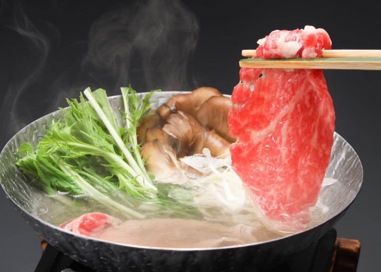 Suimeikan Gero Eksteriør bilde A piece of marbled beef being dipped into a pot of soup